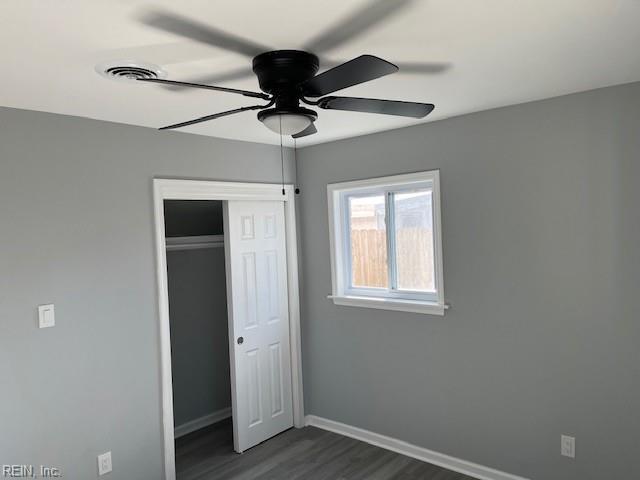 unfurnished bedroom with a closet, ceiling fan, and dark hardwood / wood-style floors