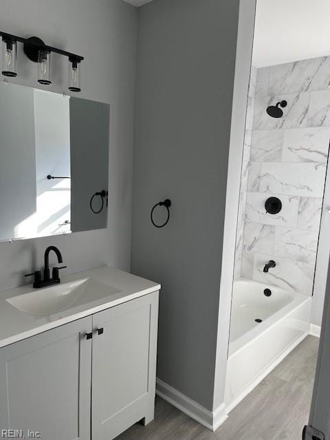 bathroom with vanity, wood-type flooring, and tiled shower / bath