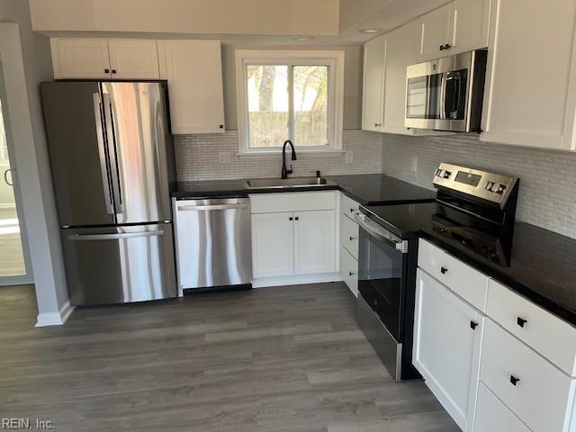 kitchen featuring dark hardwood / wood-style floors, white cabinetry, sink, and appliances with stainless steel finishes