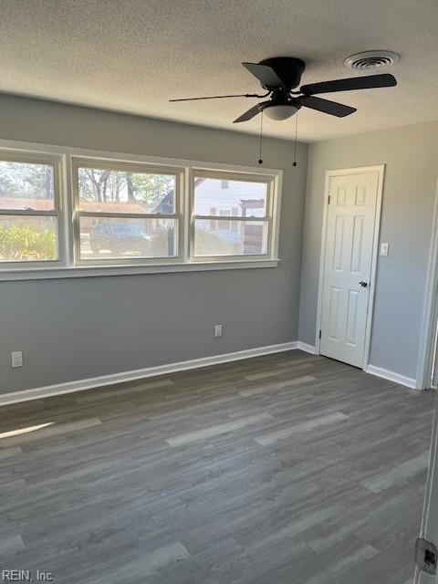 unfurnished room featuring a textured ceiling, dark hardwood / wood-style floors, and ceiling fan