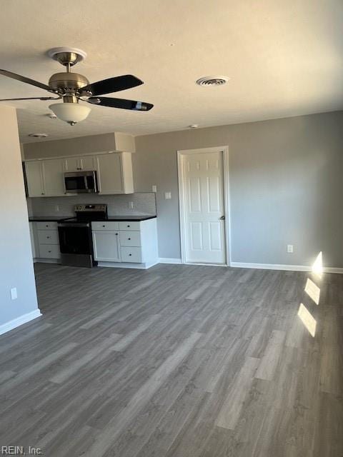 kitchen with ceiling fan, white cabinetry, stainless steel appliances, and dark wood-type flooring