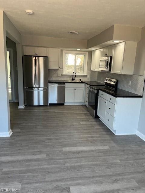 kitchen with light hardwood / wood-style floors, white cabinetry, sink, and appliances with stainless steel finishes