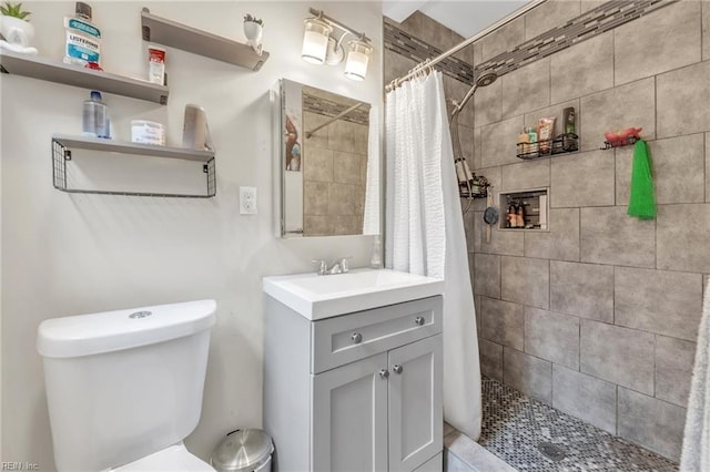 bathroom featuring toilet, vanity, and walk in shower