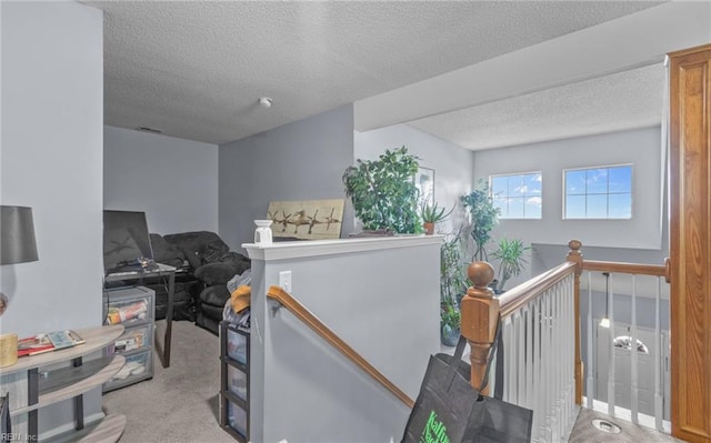 interior space with a textured ceiling and light colored carpet