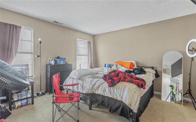 bedroom with a textured ceiling and light carpet