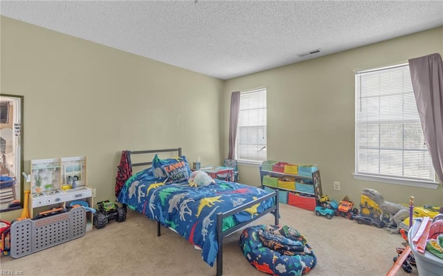 bedroom featuring a textured ceiling and light carpet