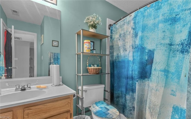 bathroom with toilet, a textured ceiling, a shower with shower curtain, and vanity