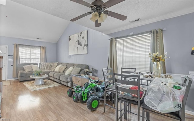 living room with lofted ceiling, a textured ceiling, ceiling fan, and light hardwood / wood-style floors