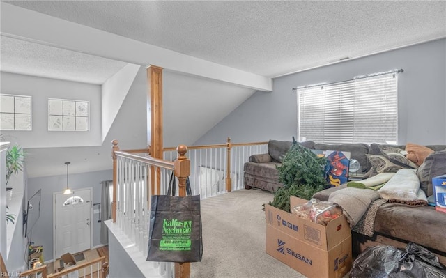 carpeted living room featuring a textured ceiling and lofted ceiling with beams