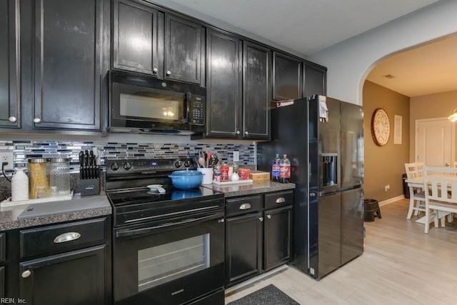 kitchen with tasteful backsplash, light hardwood / wood-style floors, and black appliances