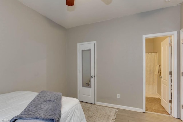 bedroom featuring light hardwood / wood-style floors, ensuite bath, and ceiling fan