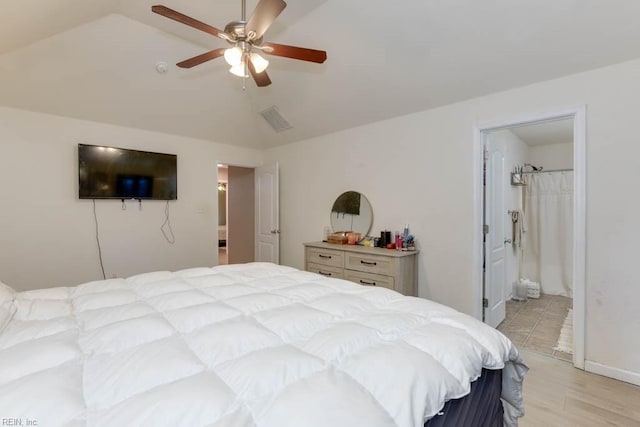 bedroom with ensuite bathroom, vaulted ceiling, and ceiling fan