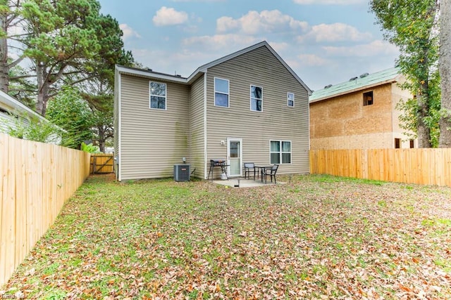 back of house with central AC, a patio area, and a lawn