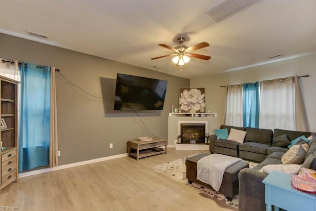 living room with light hardwood / wood-style flooring and ceiling fan