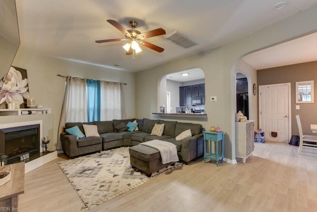 living room featuring ceiling fan and light wood-type flooring