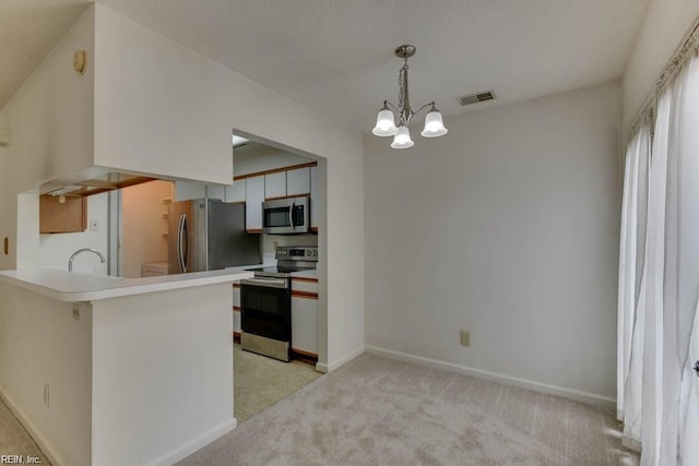 kitchen featuring light carpet, hanging light fixtures, kitchen peninsula, stainless steel appliances, and a chandelier