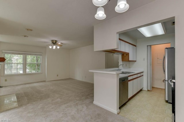 kitchen featuring light carpet, appliances with stainless steel finishes, ceiling fan, sink, and white cabinets