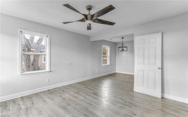 empty room with ceiling fan and light hardwood / wood-style flooring