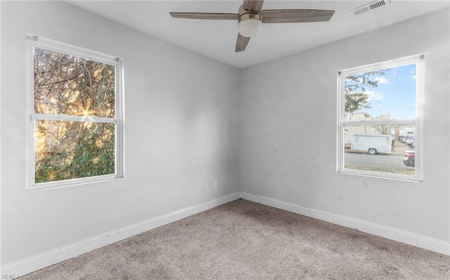 empty room featuring carpet flooring, ceiling fan, and a healthy amount of sunlight