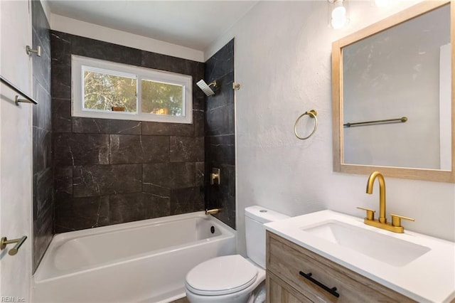 full bathroom featuring vanity, tiled shower / bath combo, and toilet