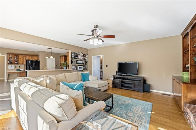 living room featuring ceiling fan and light hardwood / wood-style flooring