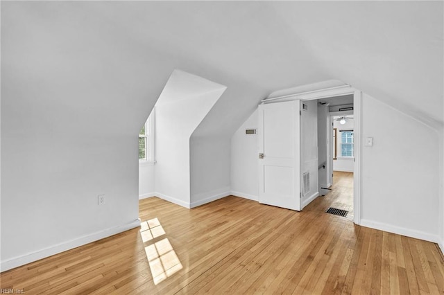 additional living space featuring light hardwood / wood-style floors and vaulted ceiling