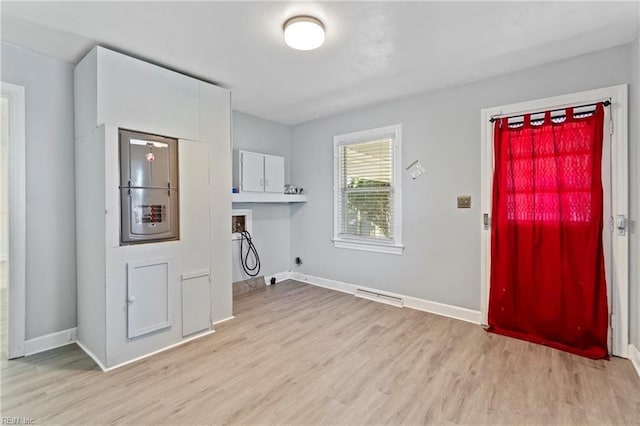 clothes washing area with hookup for a washing machine, cabinets, and light hardwood / wood-style flooring