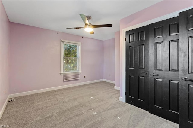 unfurnished bedroom with ceiling fan and light colored carpet