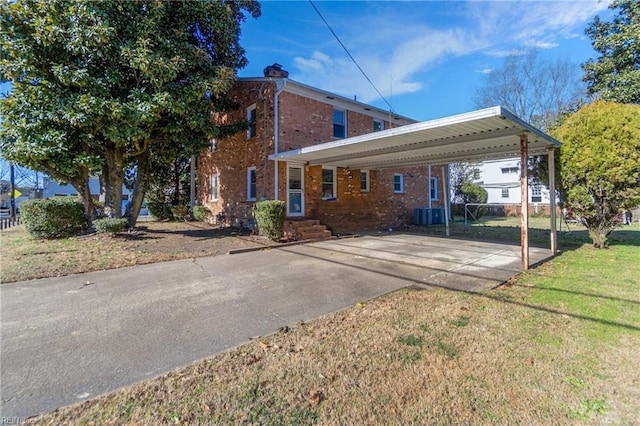 back of house featuring a carport, a lawn, and central AC