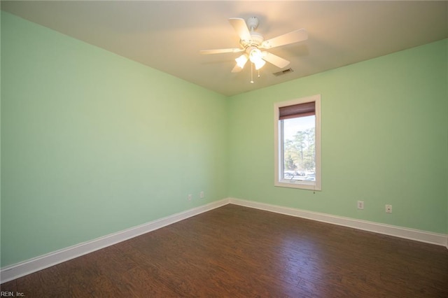 spare room with dark hardwood / wood-style floors and ceiling fan