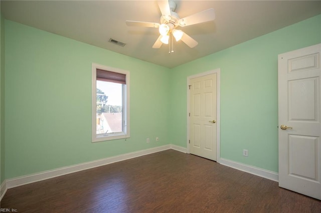 unfurnished bedroom with ceiling fan and dark wood-type flooring