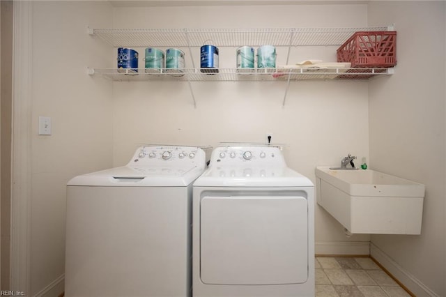 clothes washing area featuring washer and clothes dryer and sink