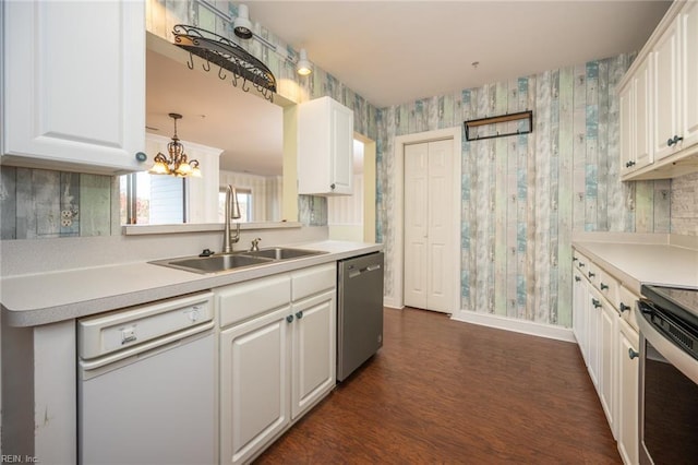 kitchen featuring pendant lighting, sink, appliances with stainless steel finishes, white cabinetry, and a chandelier