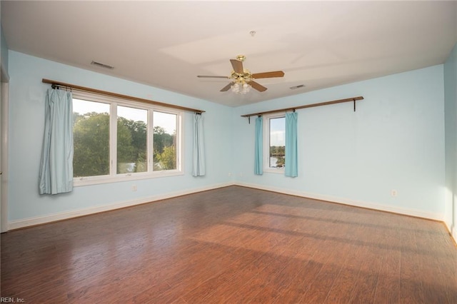 empty room with ceiling fan and dark hardwood / wood-style flooring