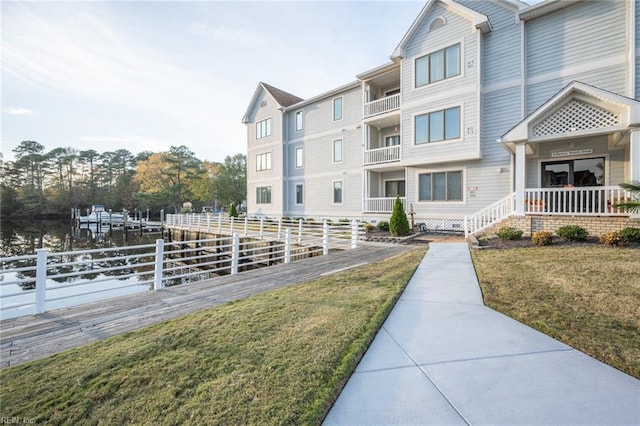 view of property's community with a lawn and a water view