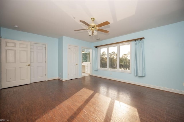 unfurnished bedroom with ceiling fan and dark wood-type flooring