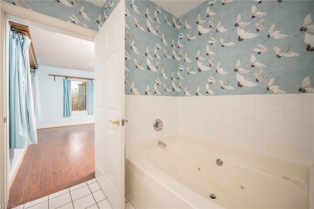 bathroom with a tub to relax in and tile patterned flooring