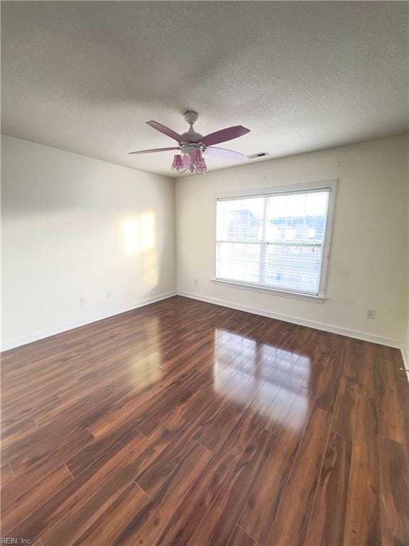 spare room with ceiling fan, dark wood-type flooring, and a textured ceiling