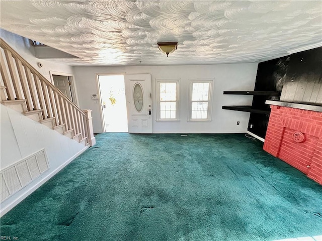 unfurnished living room featuring a textured ceiling and dark carpet