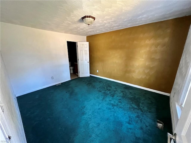 carpeted empty room featuring a textured ceiling