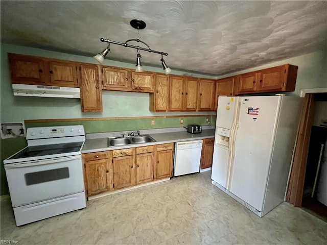 kitchen with white appliances, decorative light fixtures, and sink