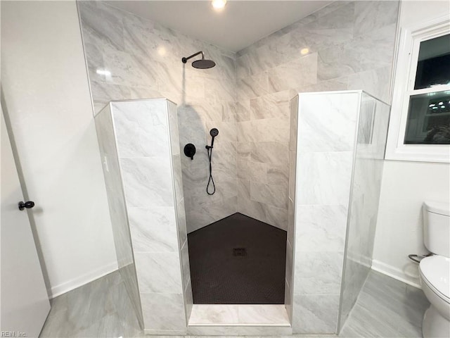 bathroom featuring toilet and a tile shower