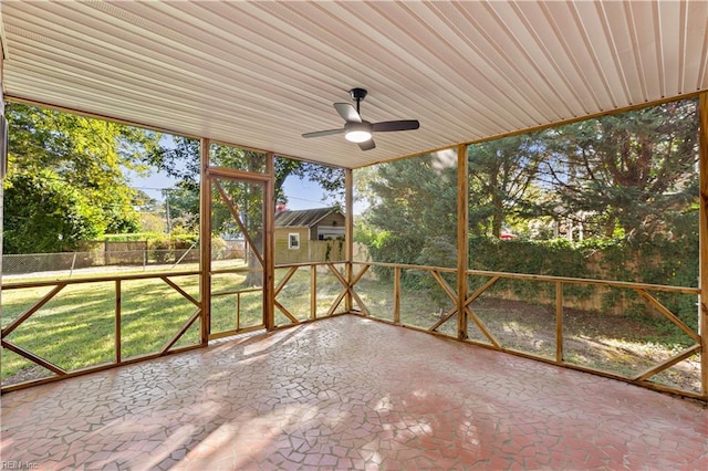 unfurnished sunroom with ceiling fan