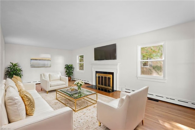 living room with light hardwood / wood-style flooring and a baseboard heating unit