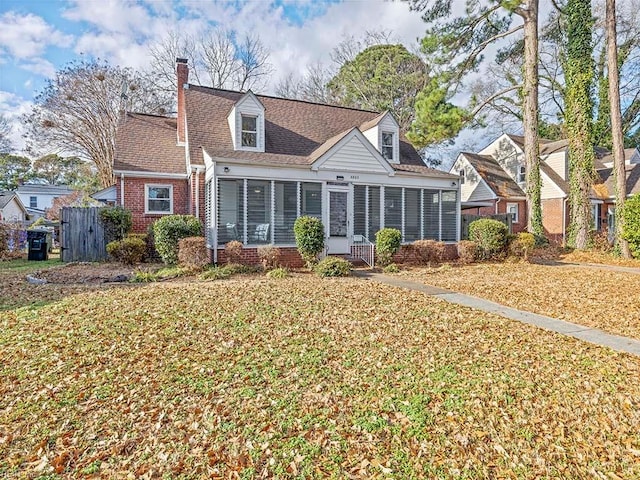 back of house with a lawn and a sunroom