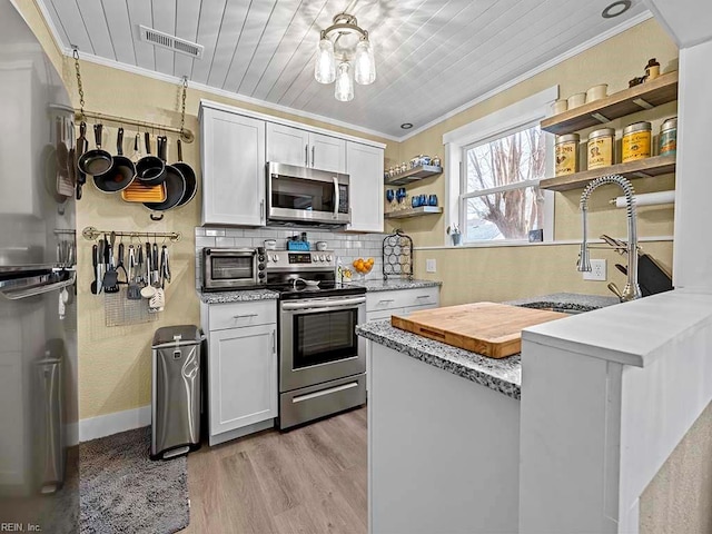 kitchen featuring stainless steel appliances, white cabinetry, ornamental molding, and sink