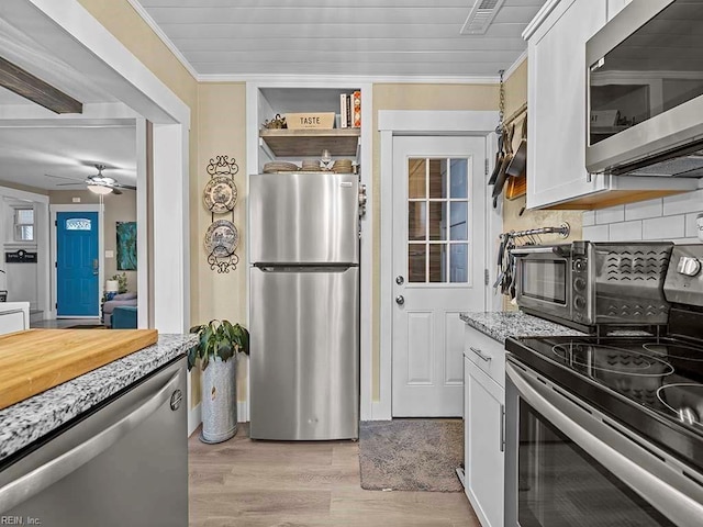 kitchen featuring backsplash, stainless steel appliances, white cabinetry, and crown molding