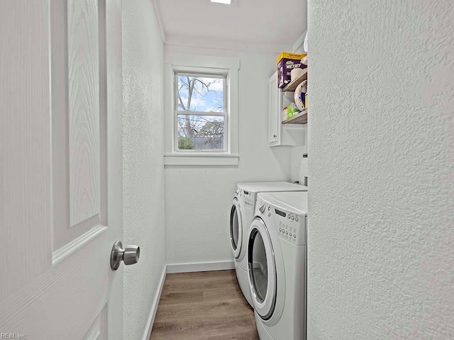 laundry area featuring cabinets, light hardwood / wood-style floors, washer and clothes dryer, and ornamental molding