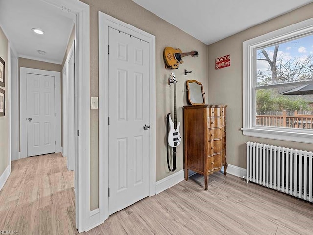 hallway with radiator and light hardwood / wood-style flooring