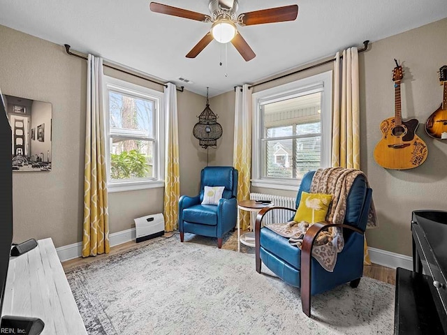 living area featuring ceiling fan and light hardwood / wood-style flooring